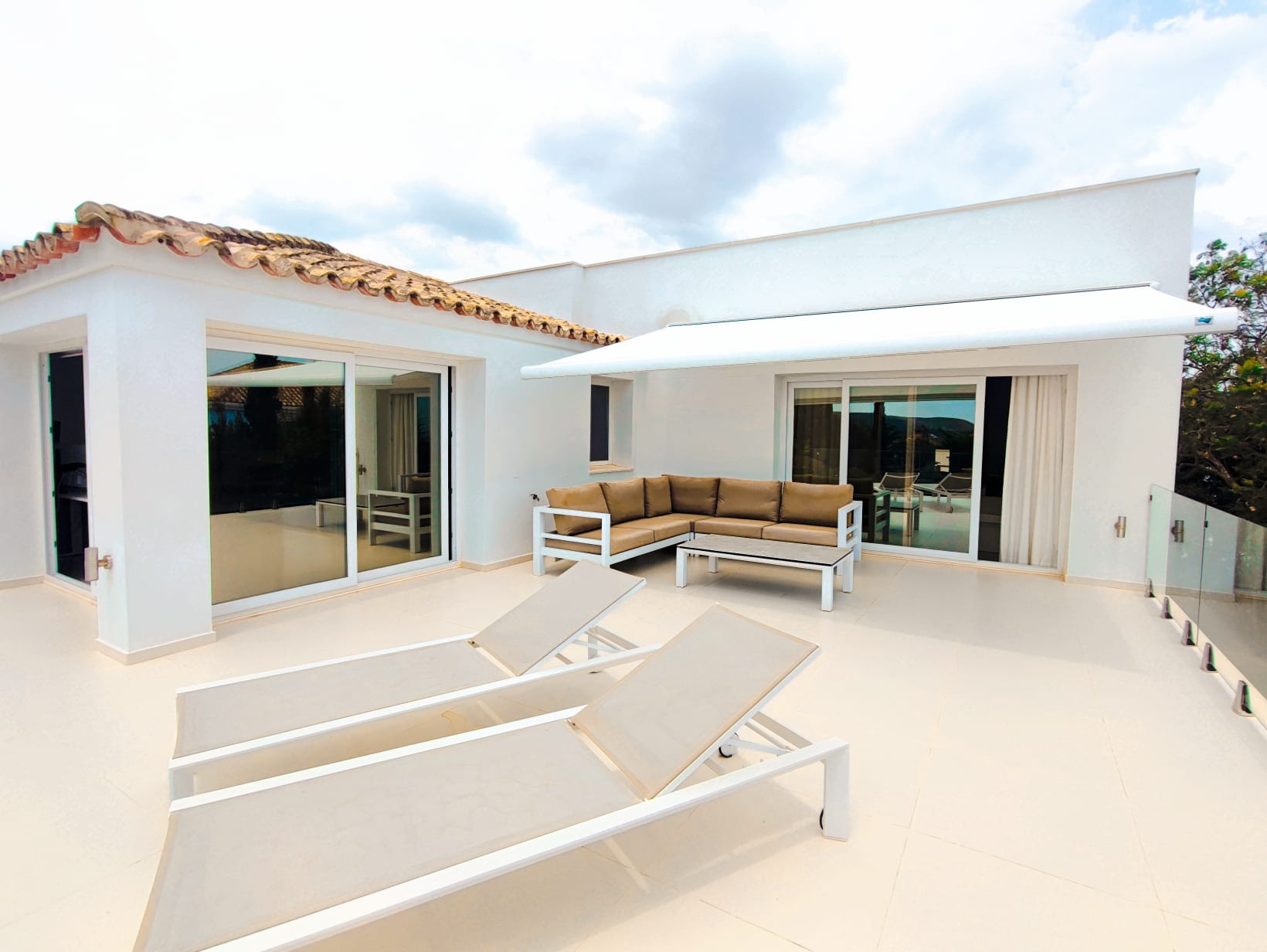 Upper sun terrace with loungers, glass balustrade and retractable awning
