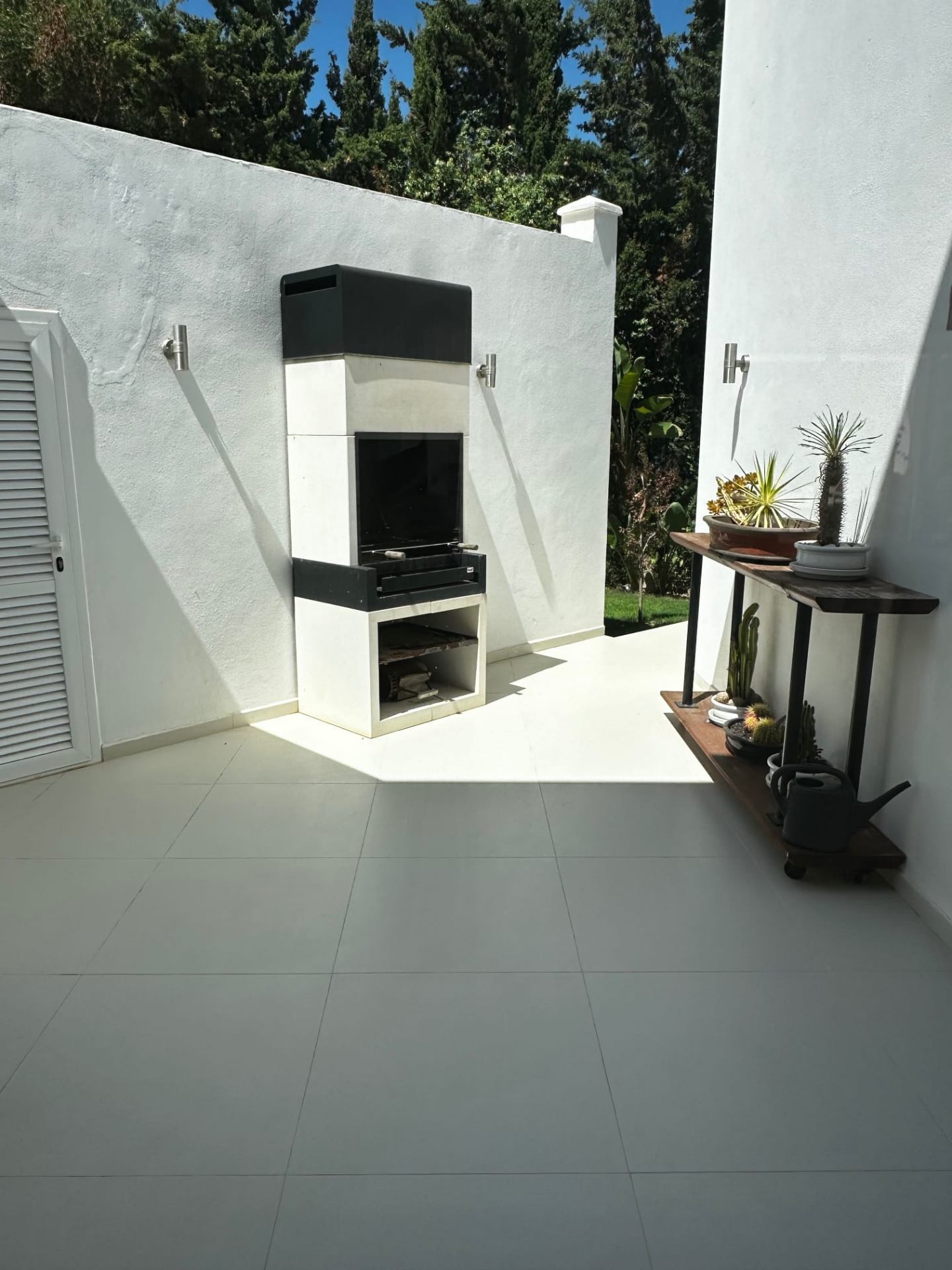 Private outdoor BBQ courtyard with chimney grill and cactus garden